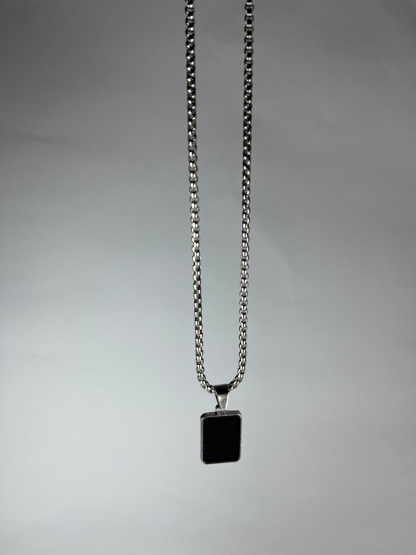 Necklace with a square pendant on a gray background