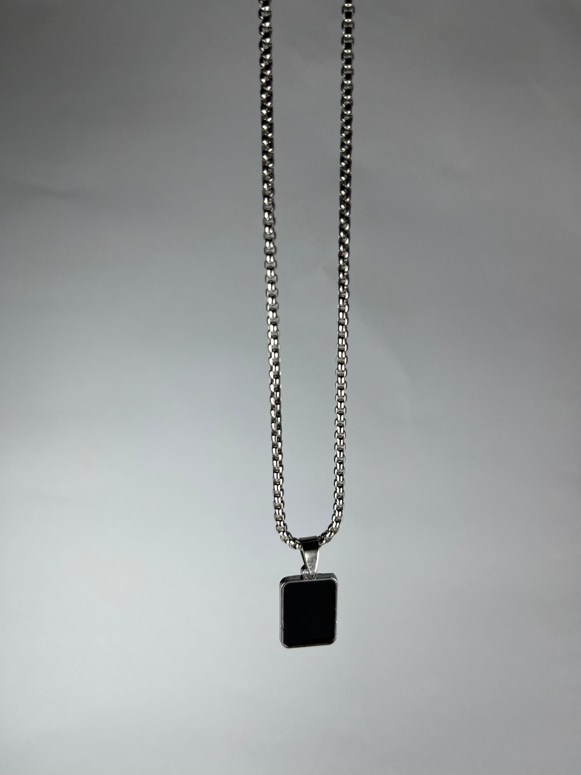 Necklace with a square pendant on a gray background