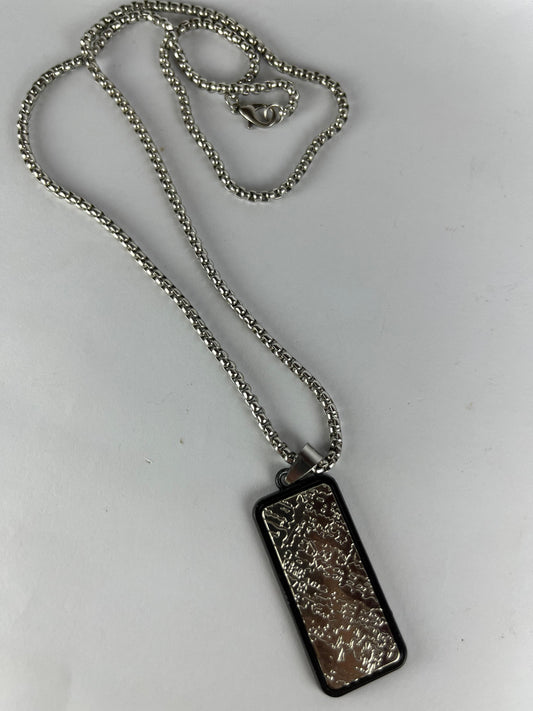 Silver necklace with a rectangular pendant on a white background